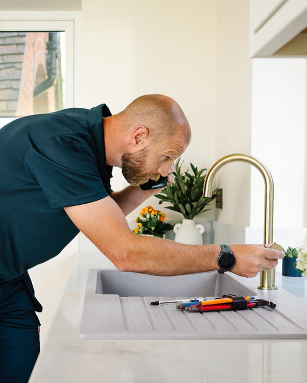 Installer fitting a Bristan Easyfit kitchen tap from above using Top Fix technology