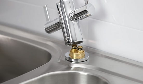 An image of an easy fit bristan kitchen tap being installed onto a kitchen sink